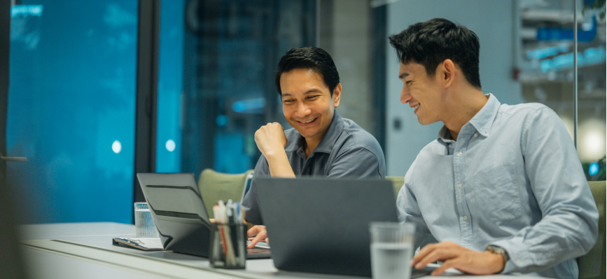 This image shows two men looking at a computer. 