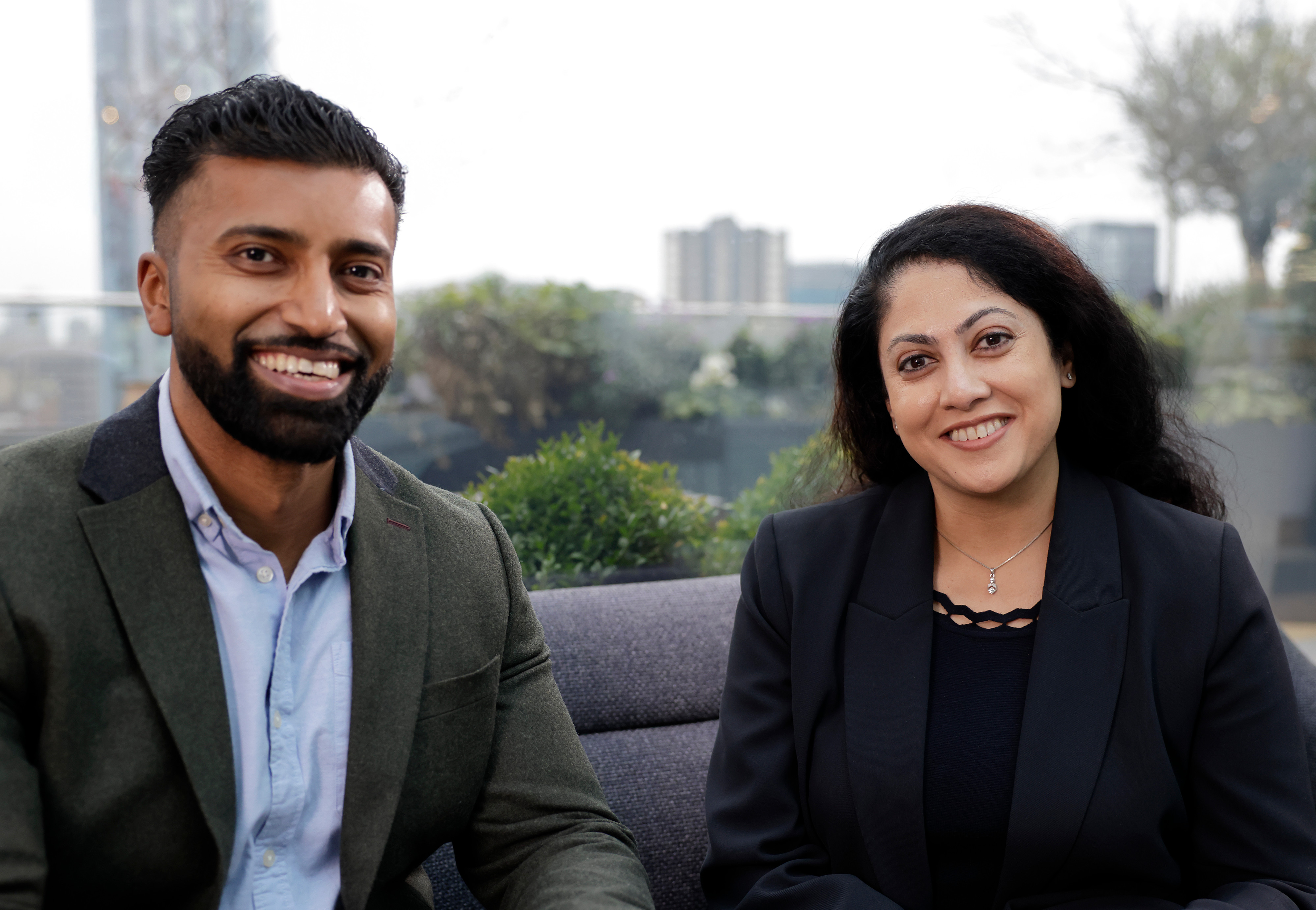 This image shows a male and a female sat down looking to camera. 