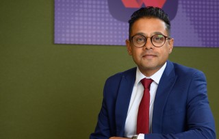 This image shows NatWest colleague Dipesh sitting at a table. 