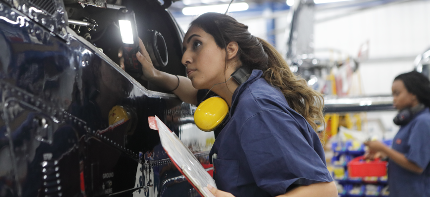 This image shows a female mechanic inspecting a car.