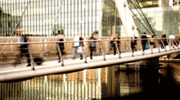 People walking on modern metal bridge 